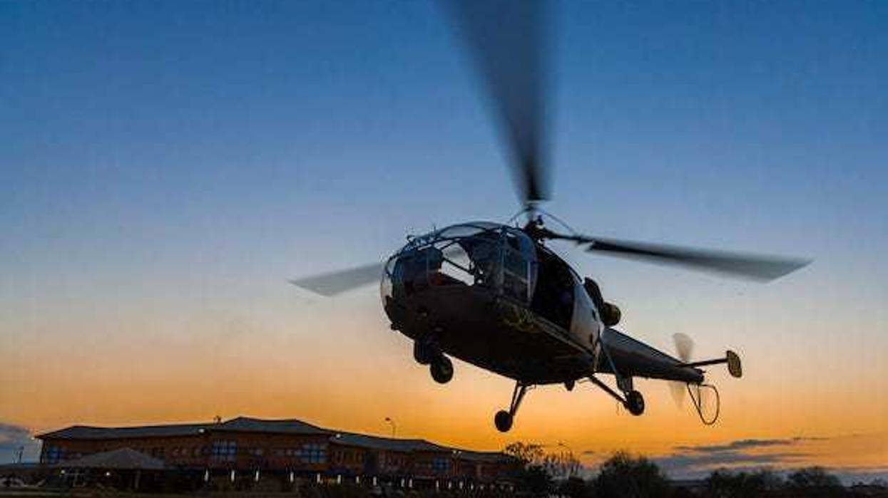 Helicopter landing at sunset to the heliport