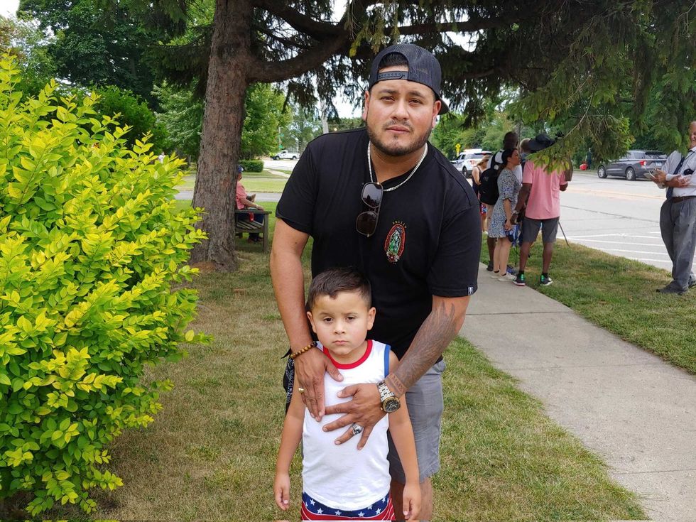 Highland Park Shooting man stands with child