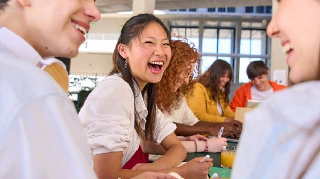 HighSchool students laughing at a cafeteria table