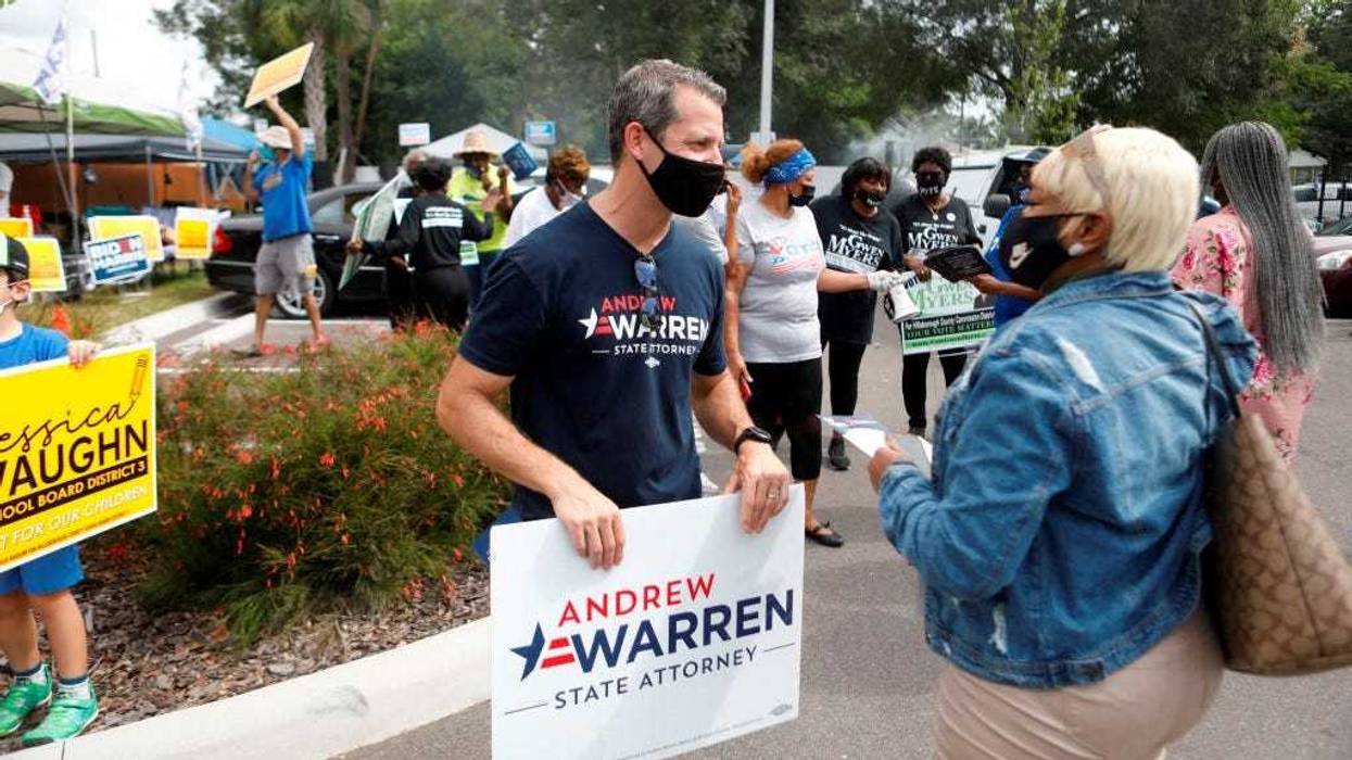 Hillsborough County State Attorney Andrew Warren talks to a voter during the NAACP Hillsborough County Branch Souls to the Polls voter drive on November 1, 2020 in Tampa, Florida.