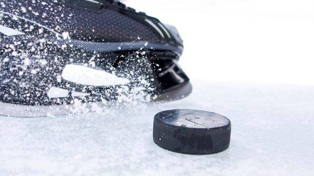 hockey skate with snow splashes and puck