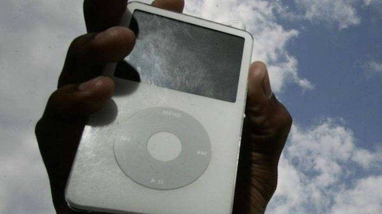 Holding an iPod against a cloudy sky