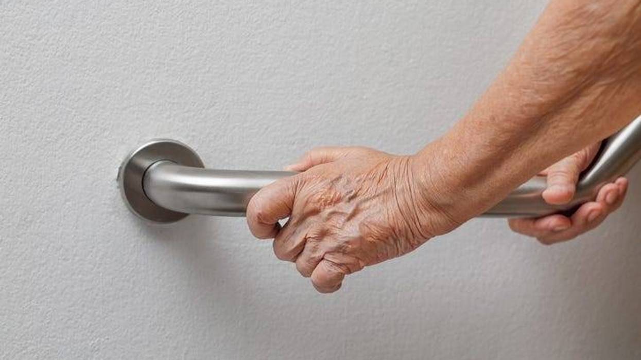 Holding on the railing to prevent falling.