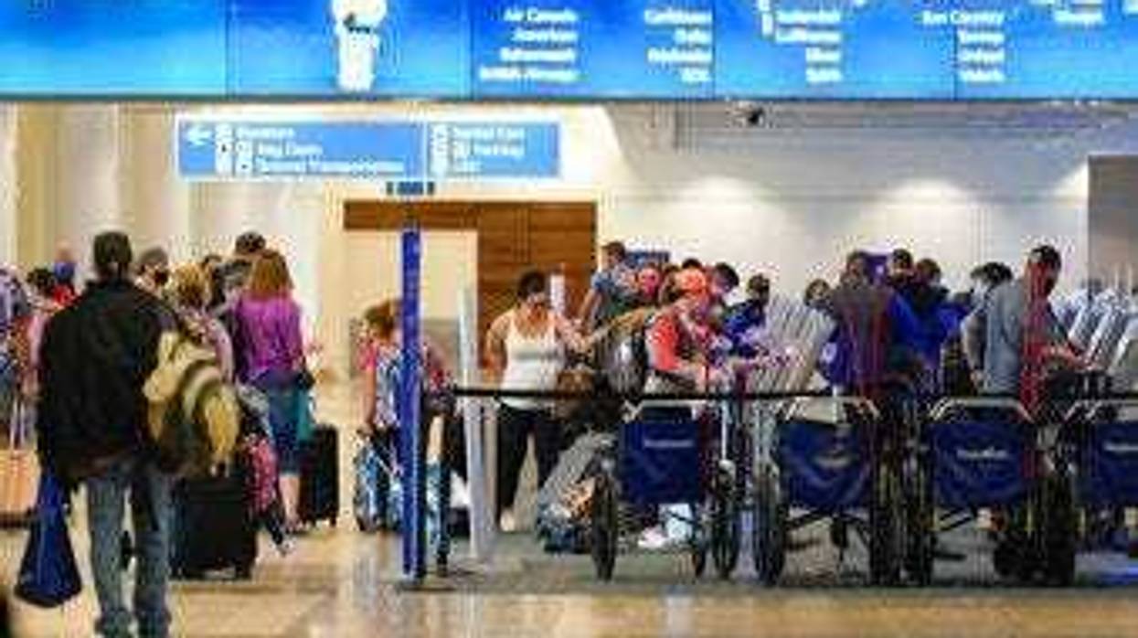 Holiday travelers check in at kiosks near an airline counter at Orlando International Airport Tuesday, Nov. 24, 2020, in Orlando, Fla. (AP Photo/John Raoux)