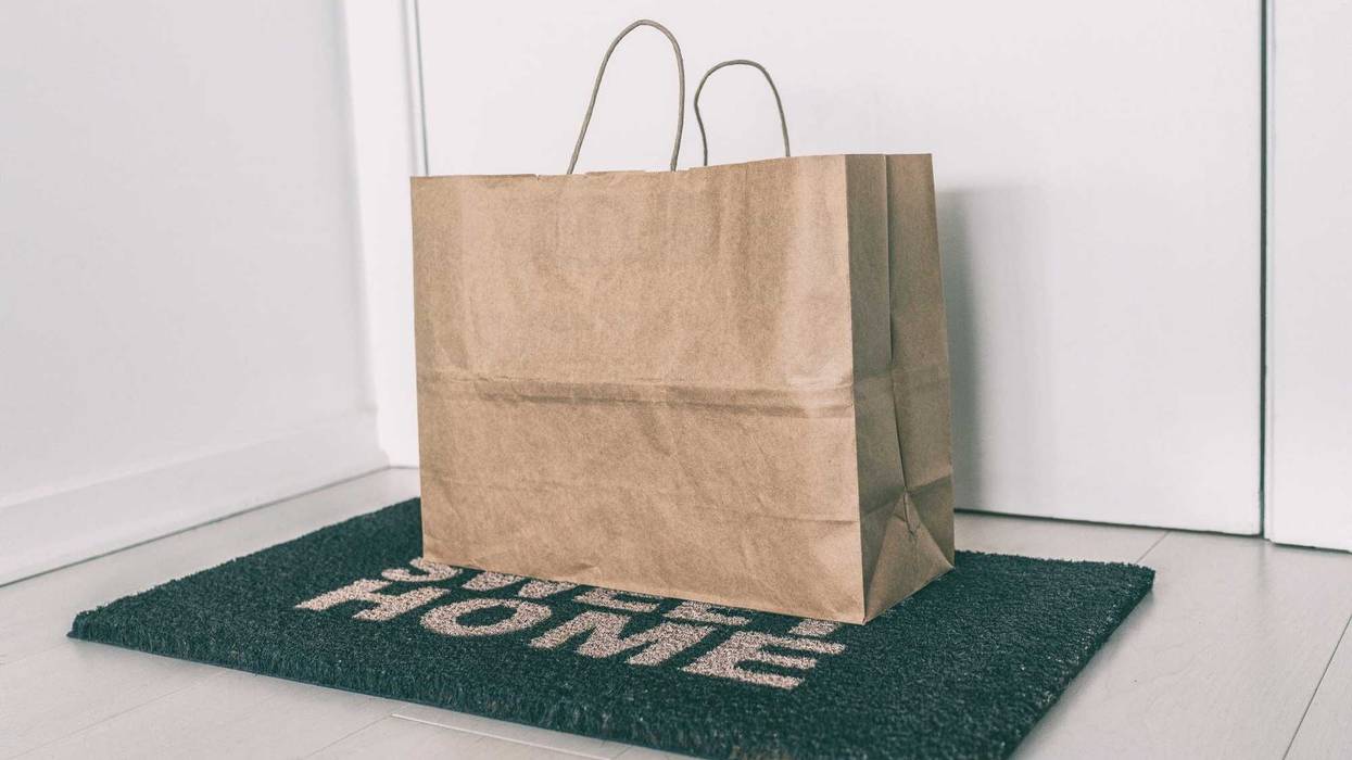 Home delivery of food grocery bag left at door mat for Corona virus spreading safety. Precaution measures against COVID-19, paper bag delivered without contact.