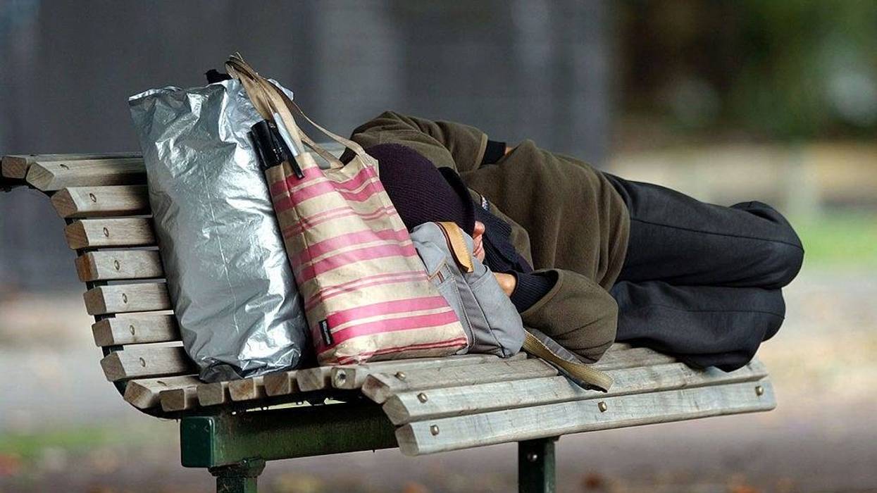 Homeless person sleeping on a park bench at Victoria Park, Auckland.
