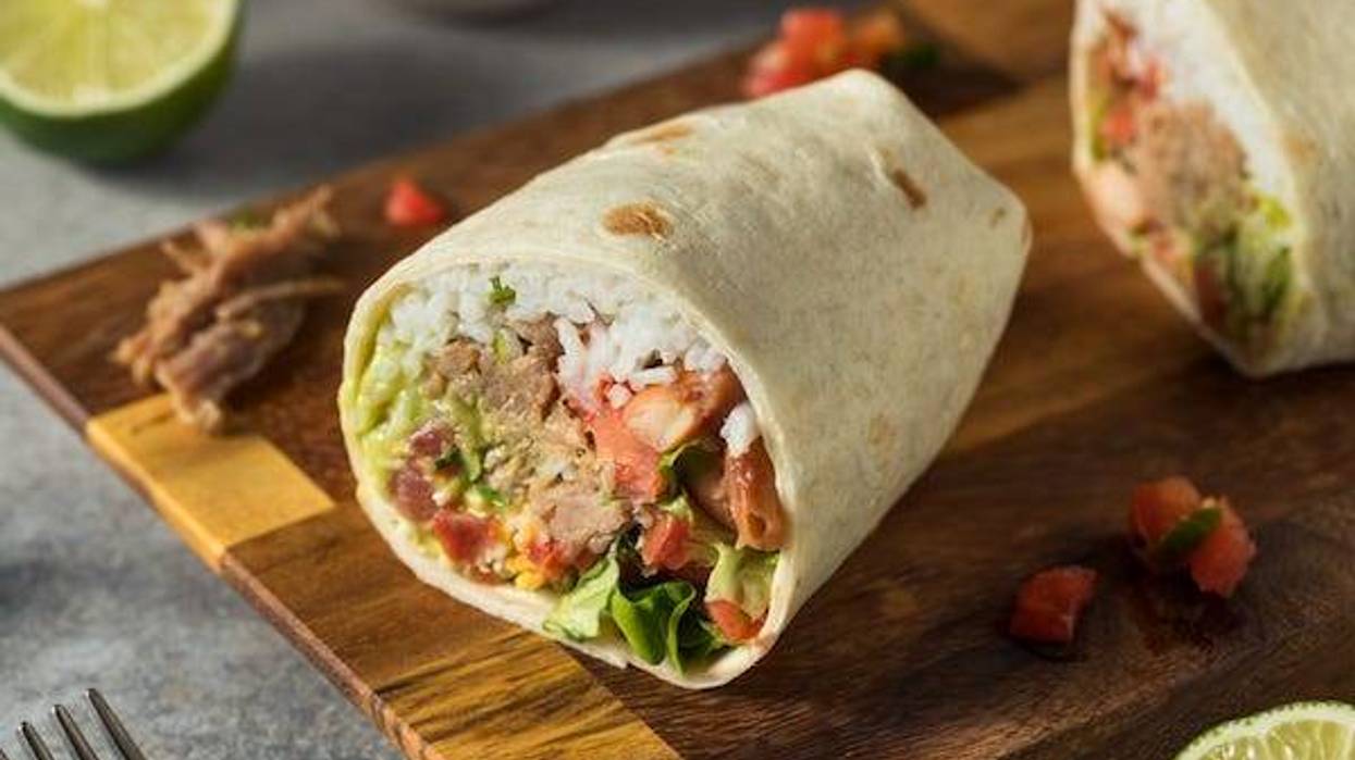 Homemade carnitas pork burrito with rice, cilantro, and guacamole