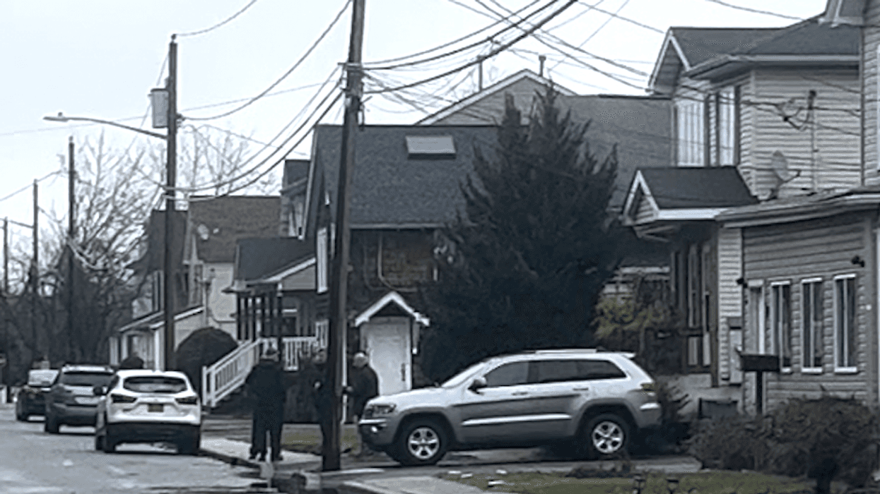 Homicide detectives are seen walking in and out of the home in Amityville on Tuesday morning