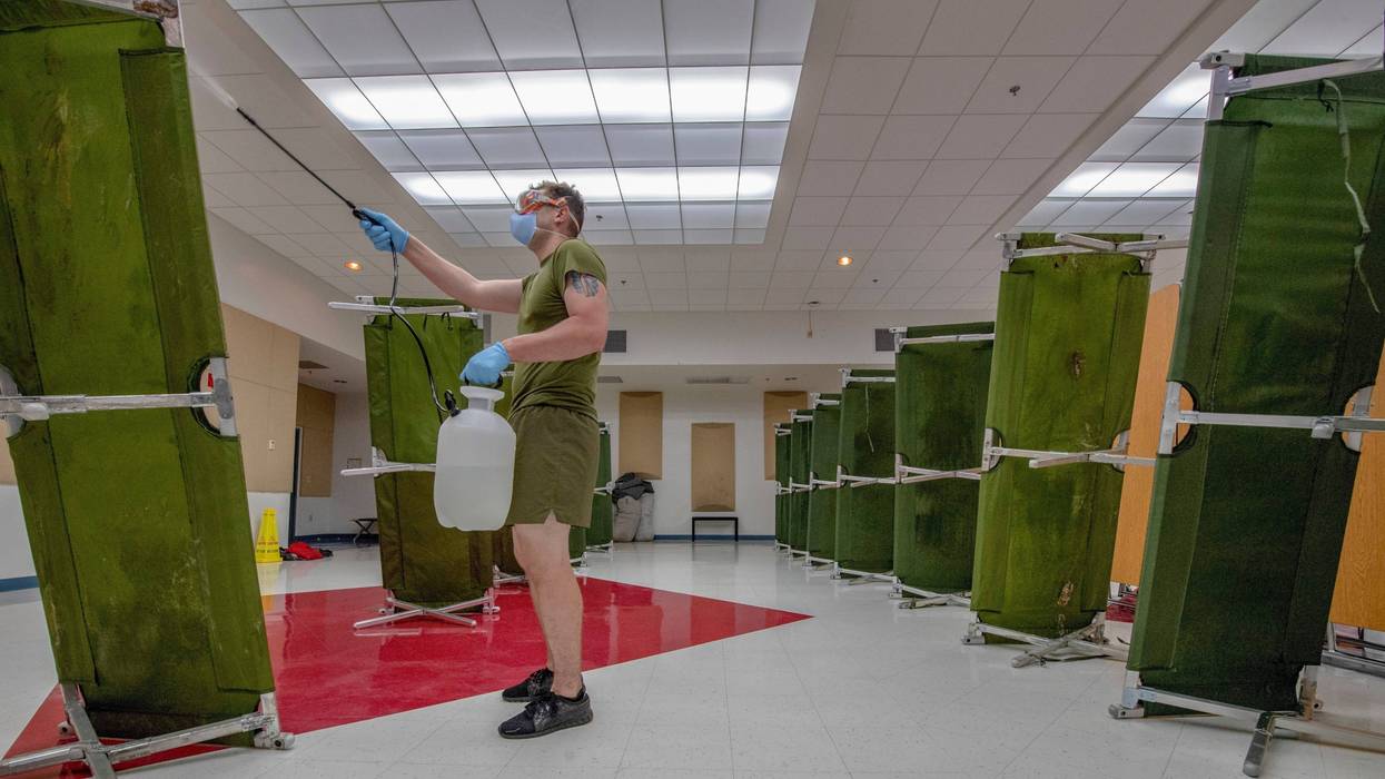 Hospital Corpsman sterilizes a building in support of USS Theodore Roosevelt