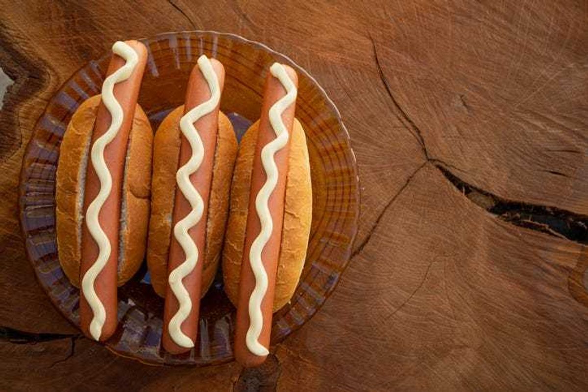 Hotdogs with mayonnaise on them.