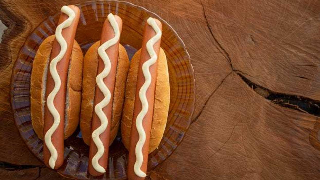 Hotdogs with mayonnaise on them.