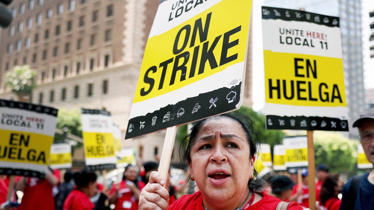 hotel workers with picket signs that say on strike