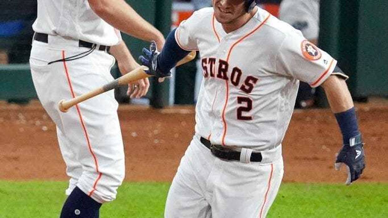 Houston Astros' Alex Bregman hand his bat to first base coach Don Kelly after a home run against the Washington Nationals during the first inning of Game 6 of the baseball World Series Tuesday, Oct. 29, 2019, in Houston.