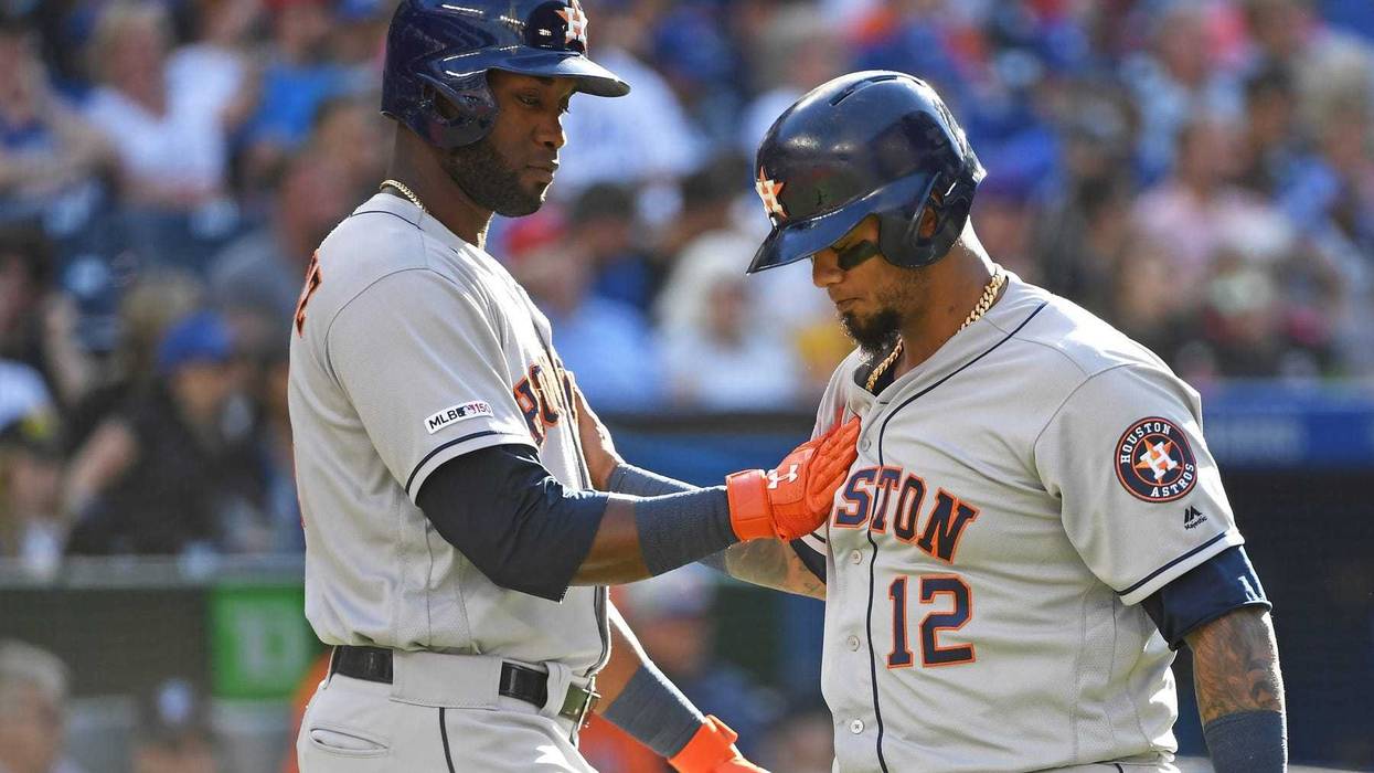 Houston Astros catcher Martin Maldonado (12) celebrates with designated hitter Yordan Alvarez (44) after scoring on a walk against the Toronto Blue Jays at Rogers Centre.