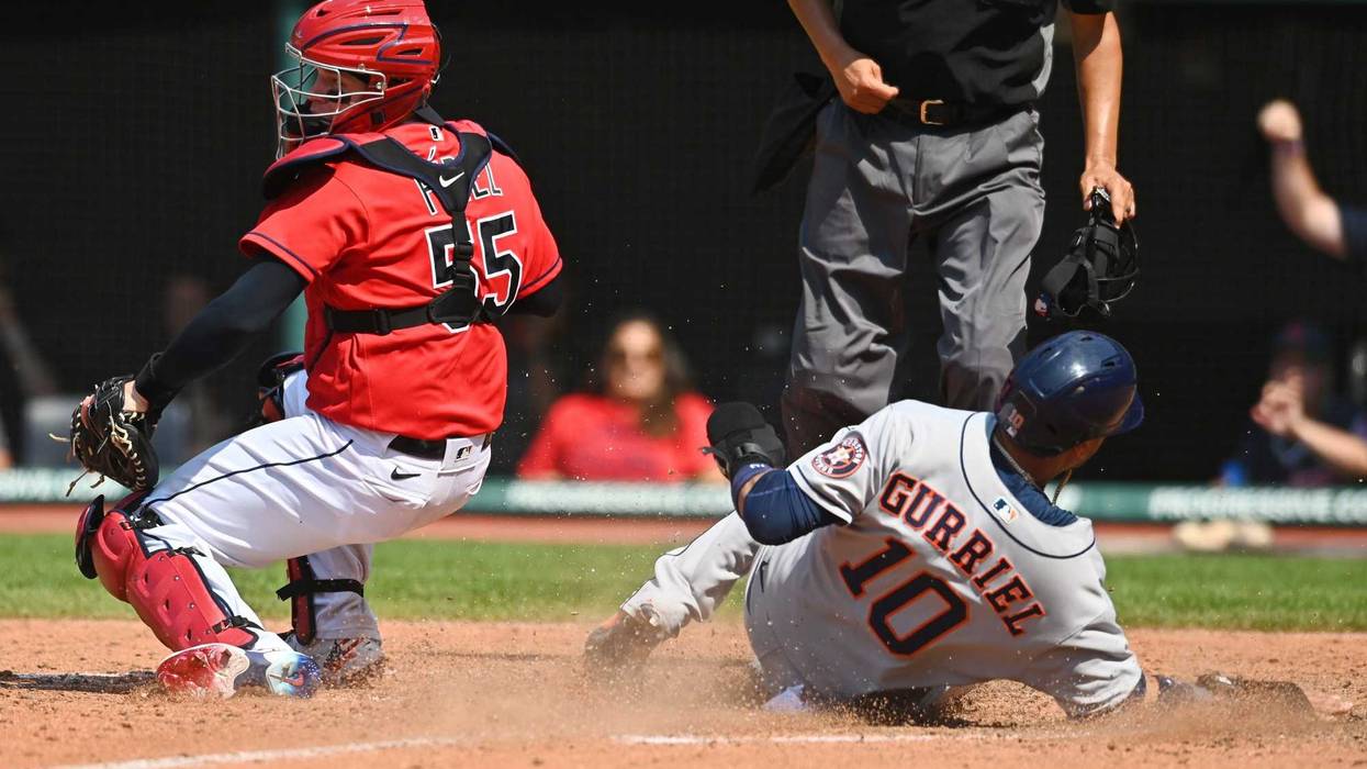 Houston Astros first baseman Yuli Gurriel (10) slides into home safely as Cleveland Indians catcher Roberto Perez (55) is late with the tag during the tenth inning at Progressive Field.