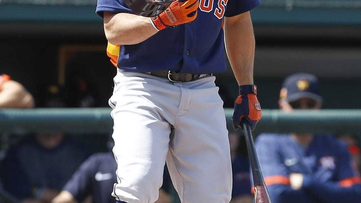 Houston Astros second baseman Jose Altuve (27) recovers his helmet after it fell off on a swing during the first inning against the Detroit Tigers at Publix Field at Joker Marchant Stadium.
