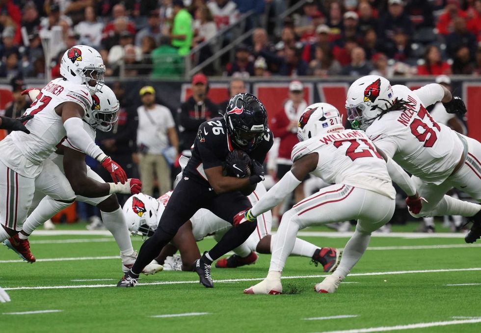 Houston Texans running back Jawhar Jordan (26) runs for a gain past Arizona Cardinals cornerback Garrett Williams (21) during the first quarter at NRG Stadium.