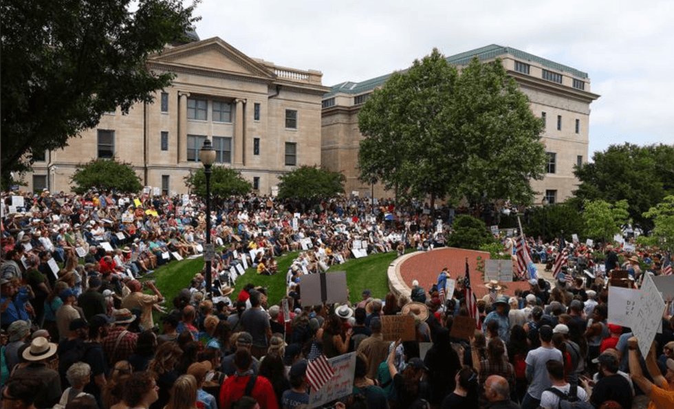 Hundreds of people gather for the "No Kings" protest Saturday at Boone County Courthouse in Columbia. The crowd sat in the warm sun as they listened to multiple speeches and chanted slogans.