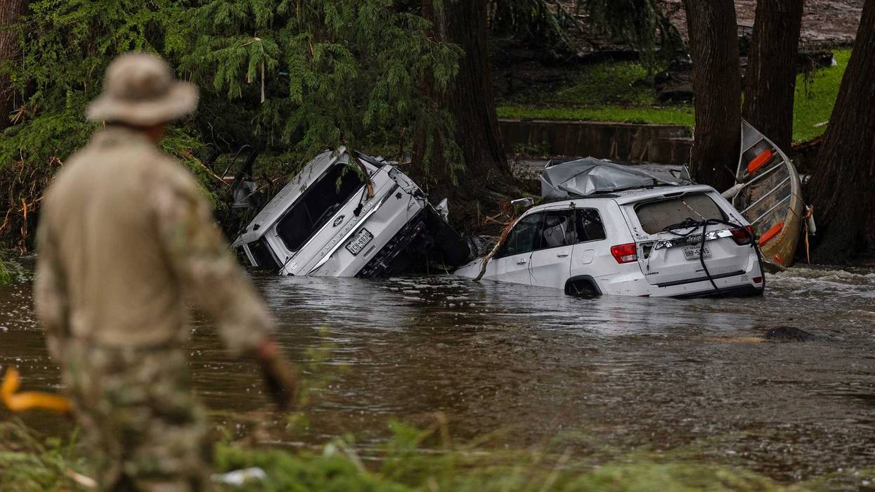 HUNT, TEXAS - JULY 6: Vehicles sit submerged as a search and rescue worker looks through debris for any survivors or remains of people swept up in the flash flooding on July 6, 2025 in Hunt, Texas. Heavy rainfall caused flooding along the Guadalupe River in central Texas with multiple fatalities reported. (Photo by Jim Vondruska/Getty Images)