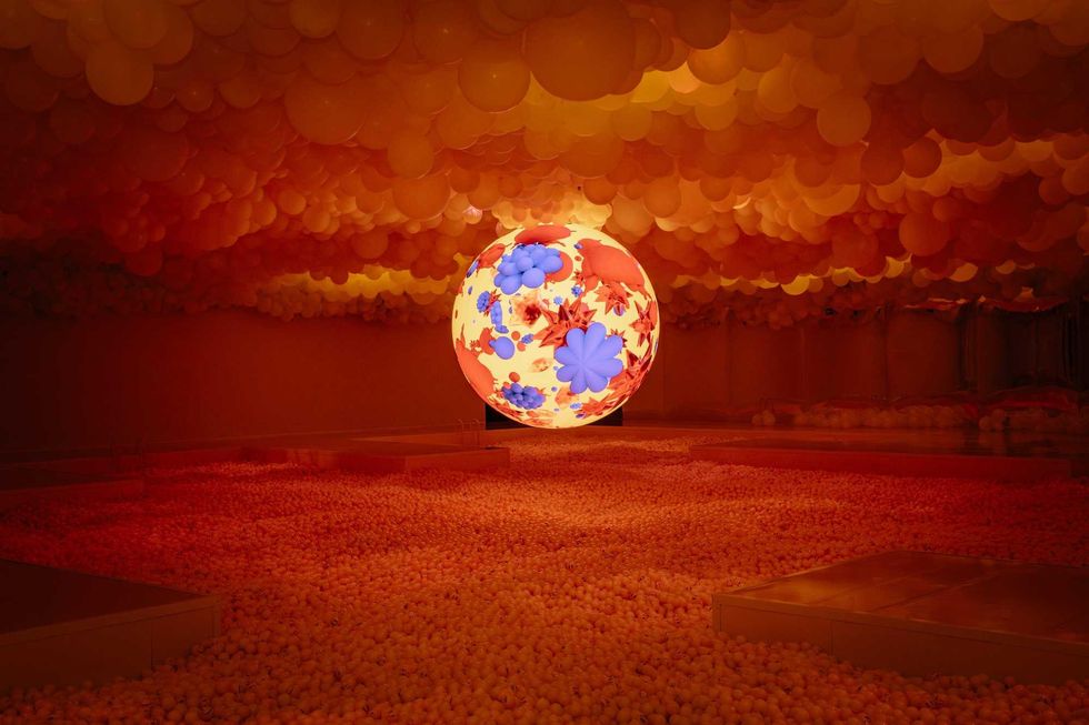 "Hyperfeeling" pool of orange balls with a balloon ceiling