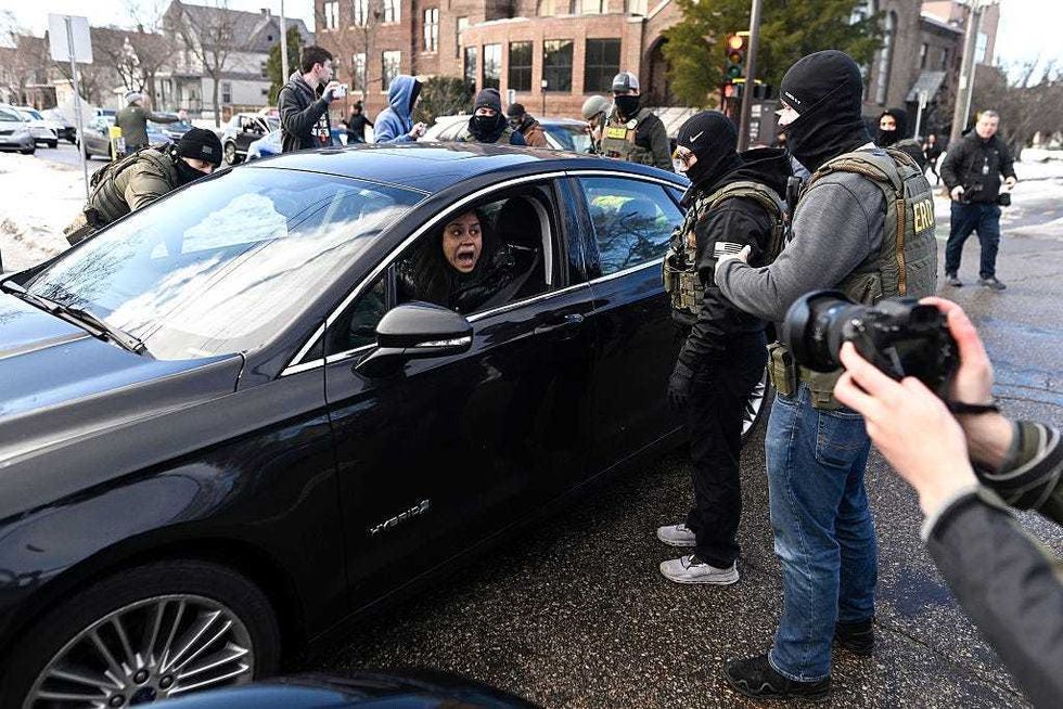 ICE agents confront a woman in a car before detaining her on January 13, 2026 in Minneapolis, Minnesota. The Trump administration has deployed over 2,400 Department of Homeland Security agents to the state of Minnesota in a push to apprehend undocumented immigrants.