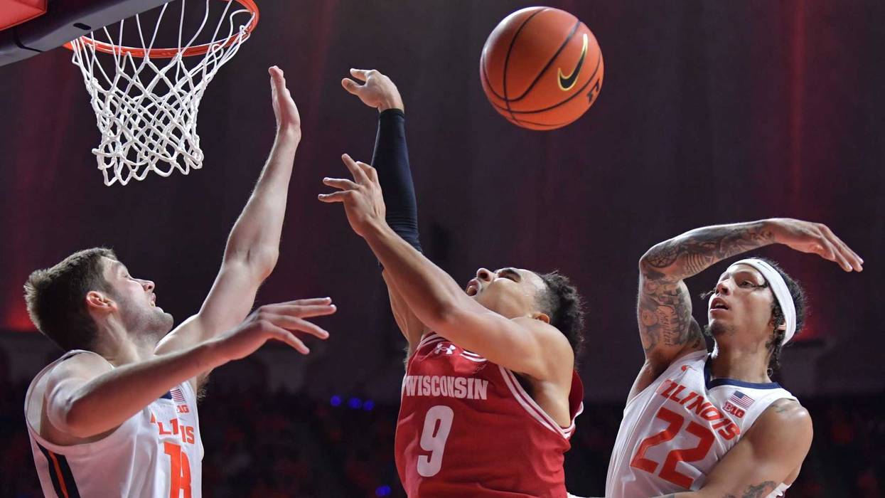 Illinois Fighting Illini guard Tre White (22) blocks the drive of Wisconsin Badgers guard John Tonje (9) as Illinois Fighting Illini center Tomislav Ivisic (13) defends during the second half at State Farm Center. Mandatory Credit: Ron Johnson-Imagn Images