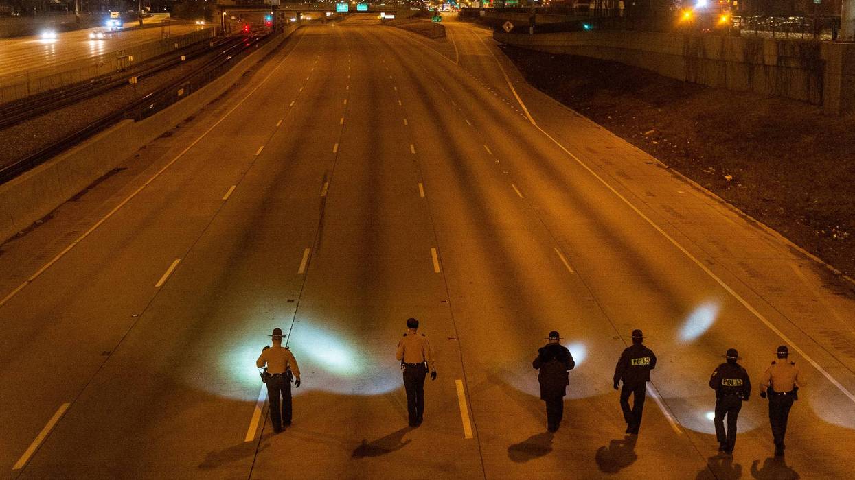Illinois State Police walk in formation, Friday morning, on the inbound I-94 Expressway near 79th Street, looking for evidence of the shooting that left one woman wounded.