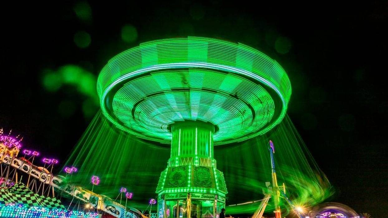 Illuminated fair ride with blurred neon lights at the Ventura County Fair.