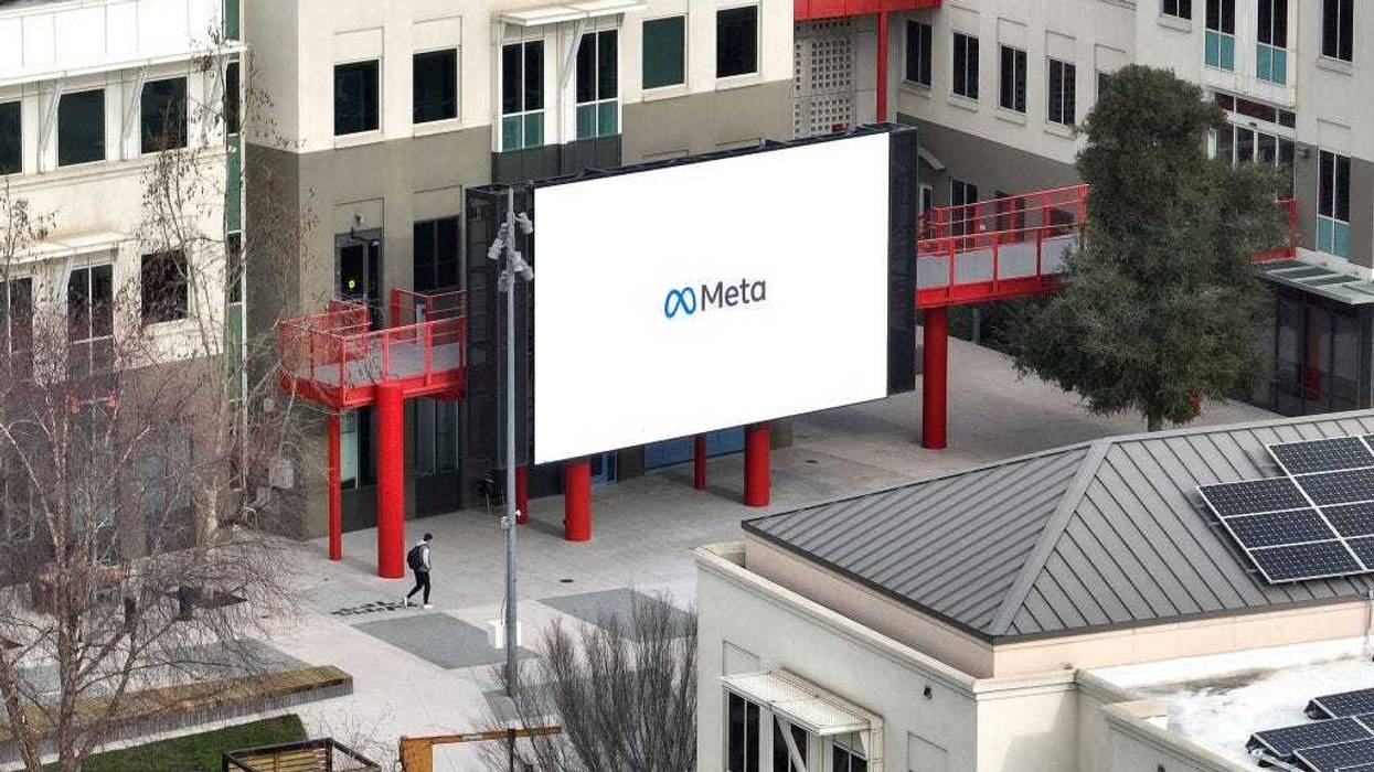 In an aerial view, a worker walks by a large video monitor on the Meta campus on February 02, 2023 in Menlo Park, California.