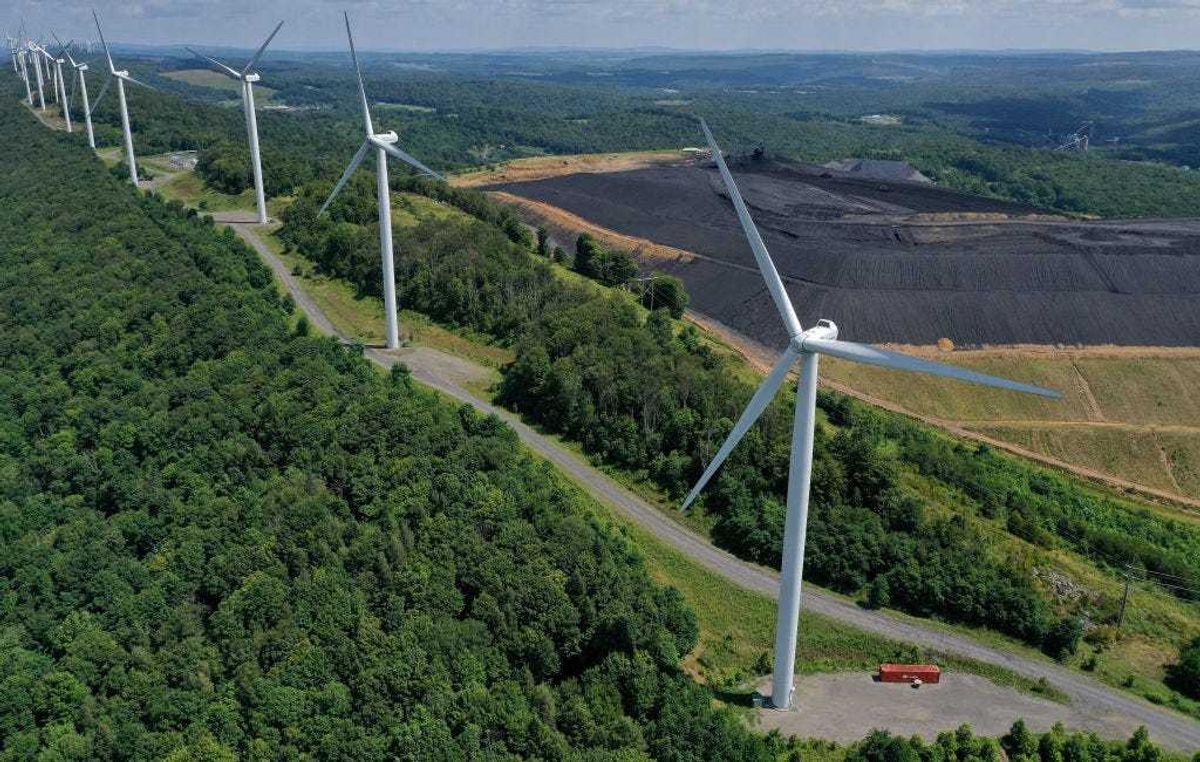 In an aerial view, turbines from the Roth Rock wind farm spin on the spine of Backbone Mountain next to the Mettiki Coal processing plant on August 23, 2022 in Oakland, Maryland. (Photo by Chip Somodevilla/Getty Images)