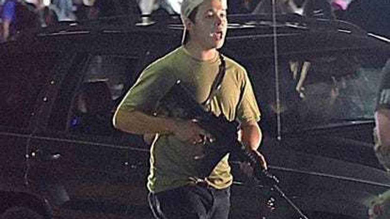 In an Aug. 25, 2020, photo, Kyle Rittenhouse carries a weapon as he walks along Sheridan Road in Kenosha during a night of unrest following the weekend police shooting of Jacob Blake.