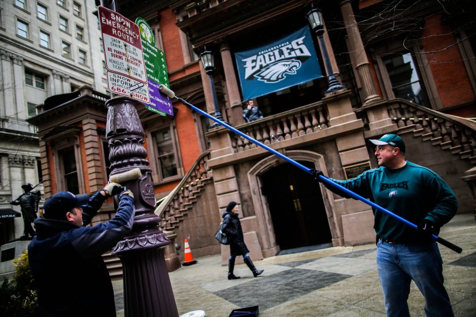 In Center City, Philadelphia police officers grease traffic light poles as a security measure for Super Bowl LII fans on Feb. 4, 2018.