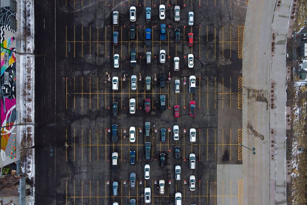 In this aerial view from a drone, cars begin to line up for a mass COVID-19 vaccination event on January 30, 2021 in Denver, Colorado.