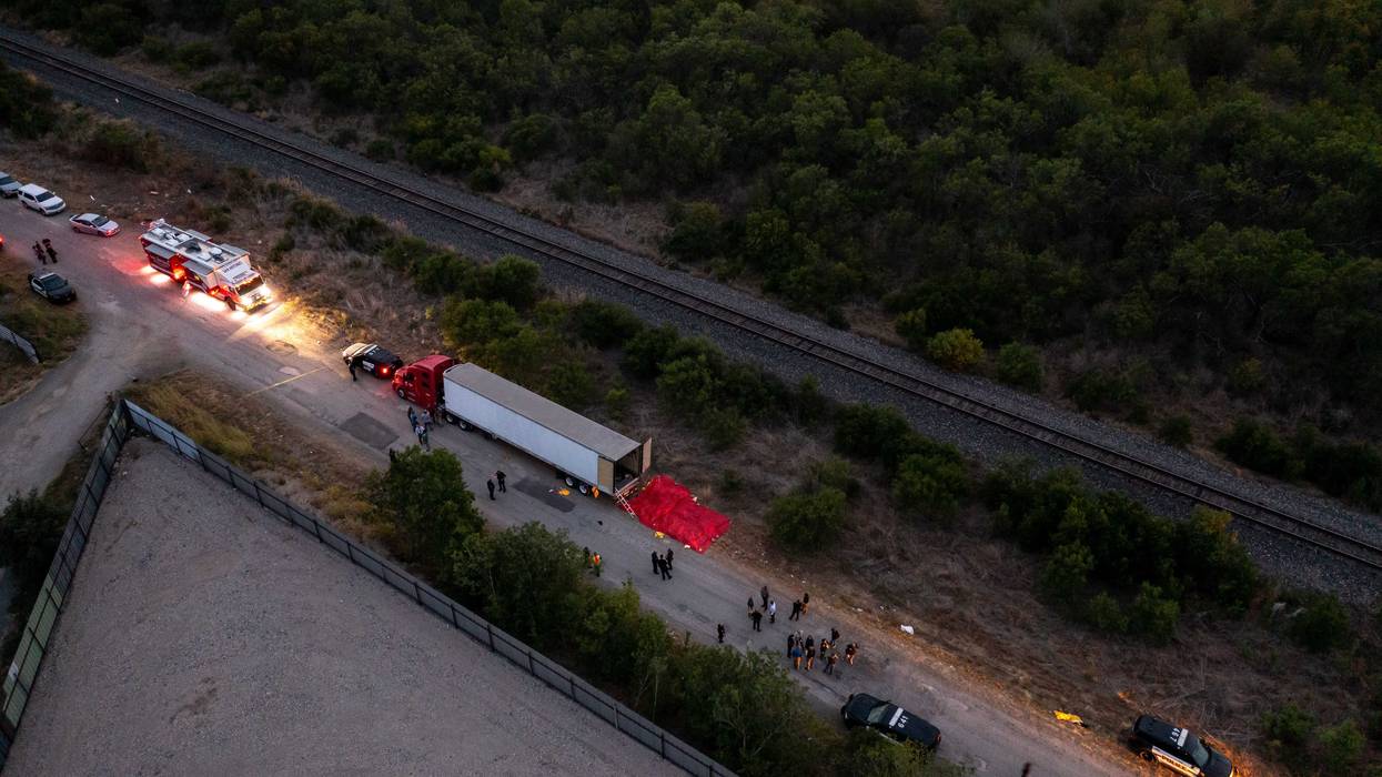 In this aerial view, members of law enforcement investigate a tractor trailer on June 27, 2022 in San Antonio, Texas. According to reports, at least 46 people, who are believed migrant workers from Mexico, were found dead in an abandoned tractor trailer.