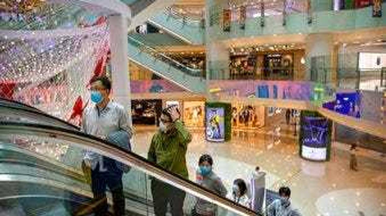 In this April 15, 2020 photo, people wear facemasks to protect against the spread of the new coronavirus as they ride an escalator at a shopping mall in Beijing. China. (AP Photo/Mark Schiefelbein)