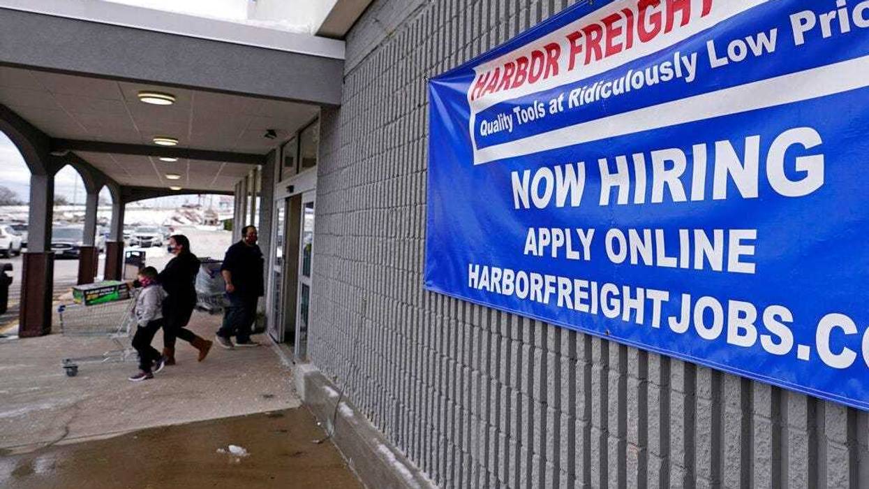 In this Dec. 10, 2020, file photo, a "Now Hiring" sign hangs on the front wall of a Harbor Freight Tools store in Manchester, N.H. (AP Photo/Charles Krupa, File)