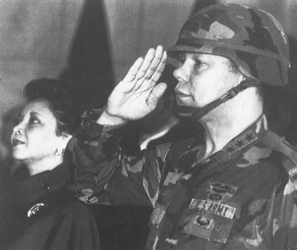 In this Dec. 30, 1986, file photo, U.S. Lieutenant General Colin Powell, commander of the 5th U.S. corps, salutes while his wife Alma stands in attention during a farewell ceremony in Frankfurt