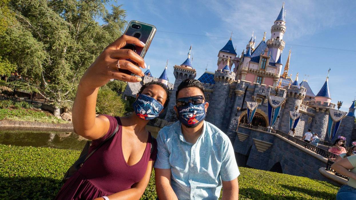 In this handout photo provided by Disneyland Resort, Guests pose in front of Sleeping Beauty Castle at the Disneyland Resort on April 30, 2021 in Anaheim, California.