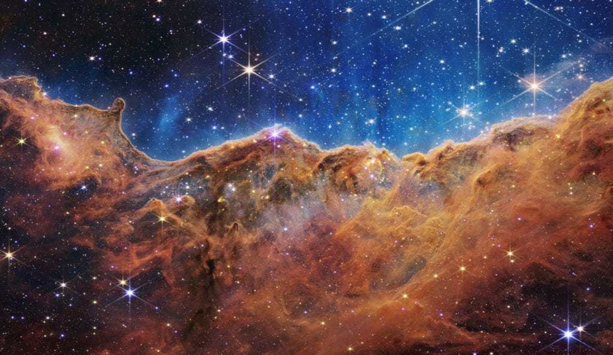 In this handout photo provided by NASA, a landscape of mountains and valleys speckled with glittering stars is actually the edge of a nearby, young, star-forming region called NGC 3324 in the Carina Nebula, on July 12, 2022 in space. Captured in infrared light by NASA's new James Webb Space Telescope, this image reveals for the first time previously invisible areas of star birth. (Photo by NASA, ESA, CSA, and STScI via Getty Images)