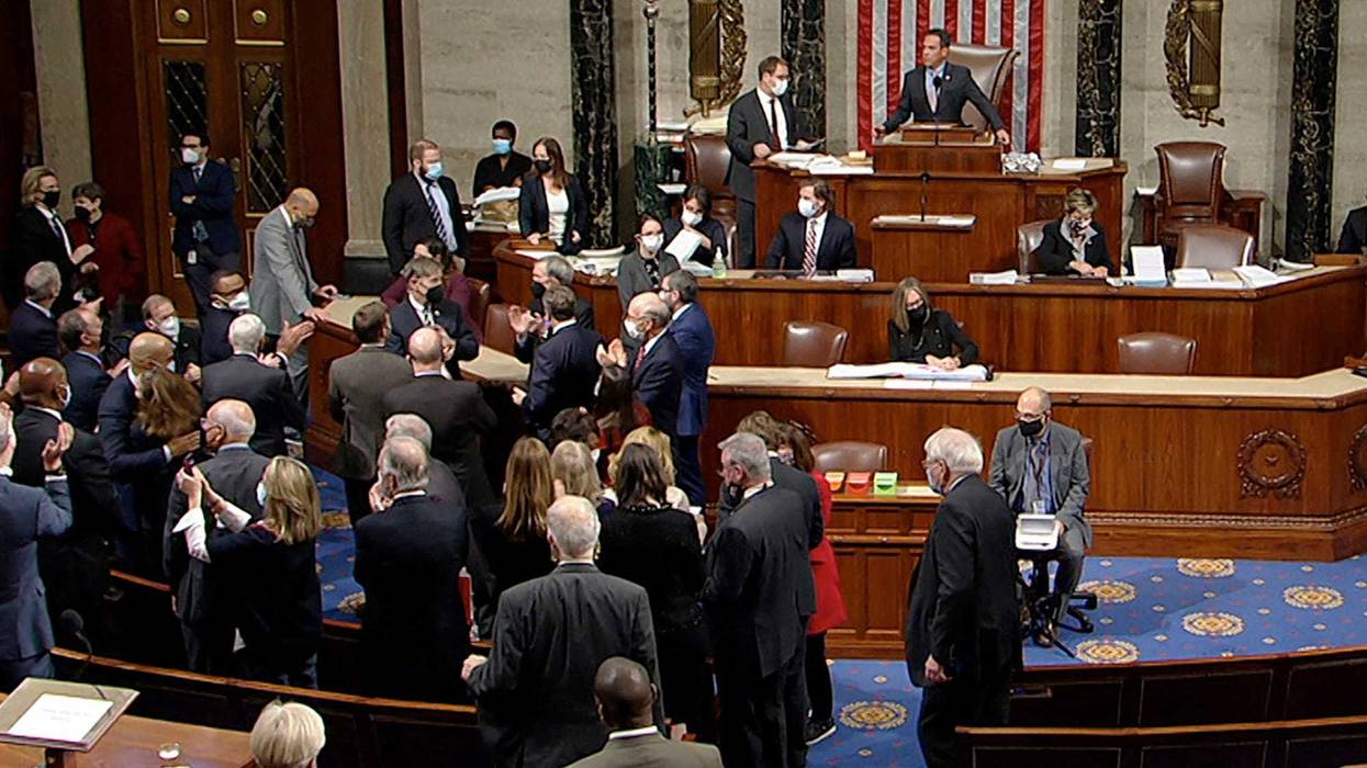 In this image from House Television, Democrats celebrate on the House floor late Friday, Nov. 5, 2021, in Washington, after the House approved a $1 trillion package of road and other infrastructure projects.