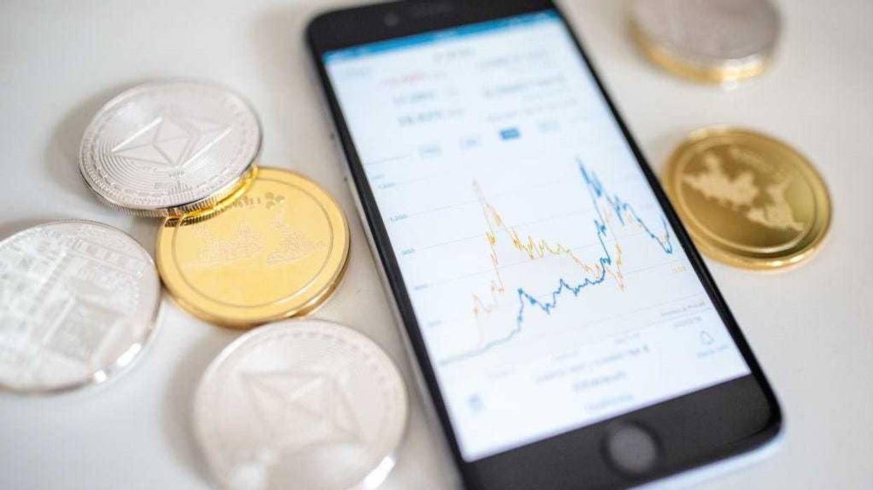 In this photo illustration of the litecoin, ripple and ethereum cryptocurrency 'altcoins' sit arranged for a photograph beside a smartphone displaying the current price chart for ethereum on April 25, 2018 in London, England.