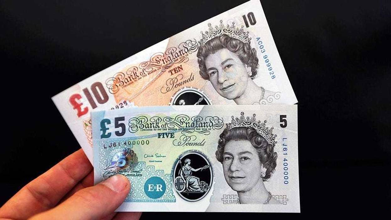 In this photo illustration, sample Polymer five and ten pound British banknotes are held during a news conference at the Bank of England on September 10, 2013 in London, England.