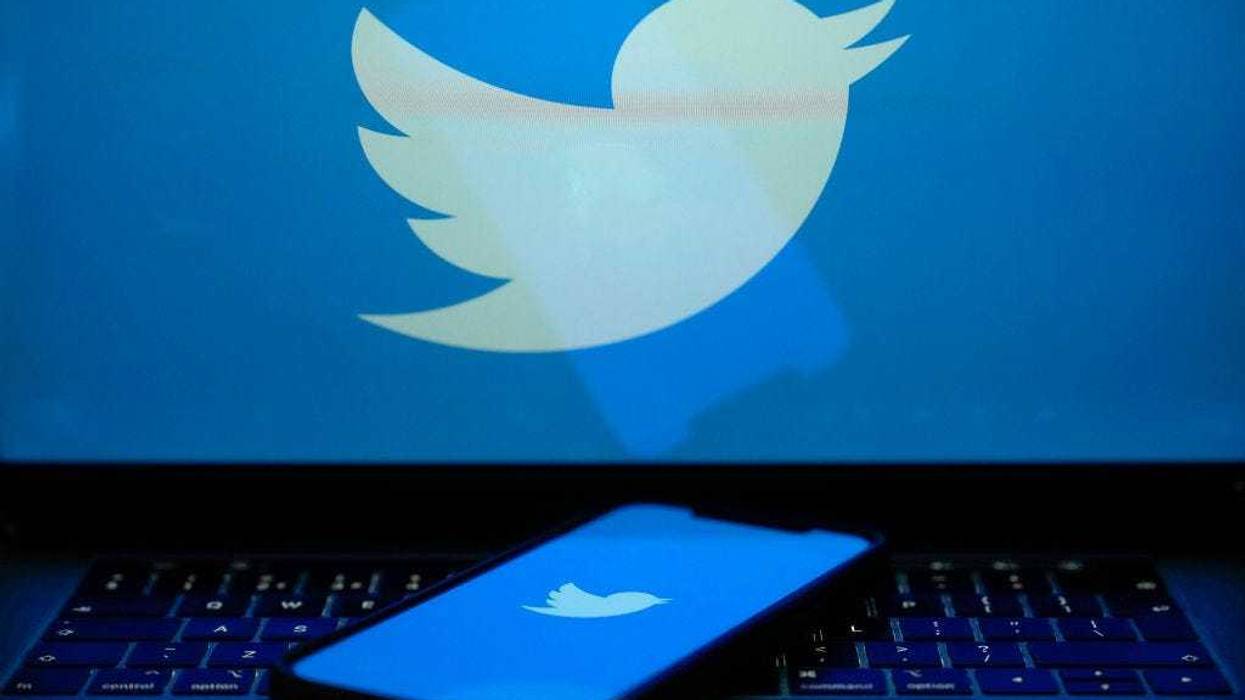 In this photo illustration the Twitter logo is seen on a computer screen and mobile cellphone.