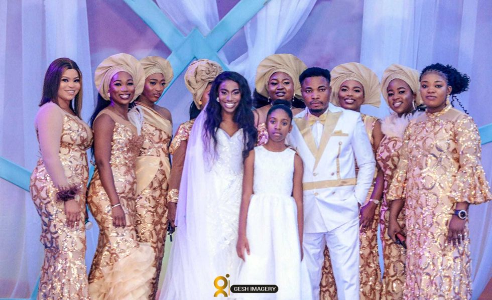 In this photo provided by Gesh Creatives, Eunice Dwumfour, center left, stands with daughter Nicole, 11, husband and fellow pastor Peter Ezechukwu and other loved ones at her Nov. 24, 2022 wedding ceremony at Champions Royal Assembly in Abuja, Nigeria