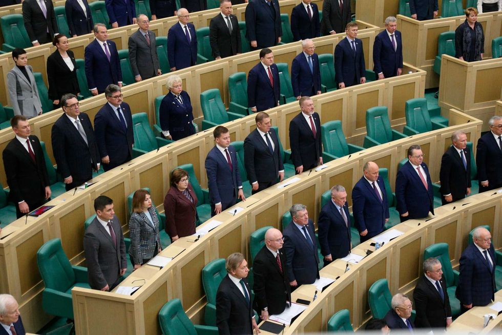 In this photo provided by the Federation Council of the Federal Assembly of the Russian Federation, lawmakers of Federation Council of the Federal Assembly of the Russian Federation listen to the national anthem as they attend a session in Moscow, Russia, Tuesday, Feb. 22, 2022
