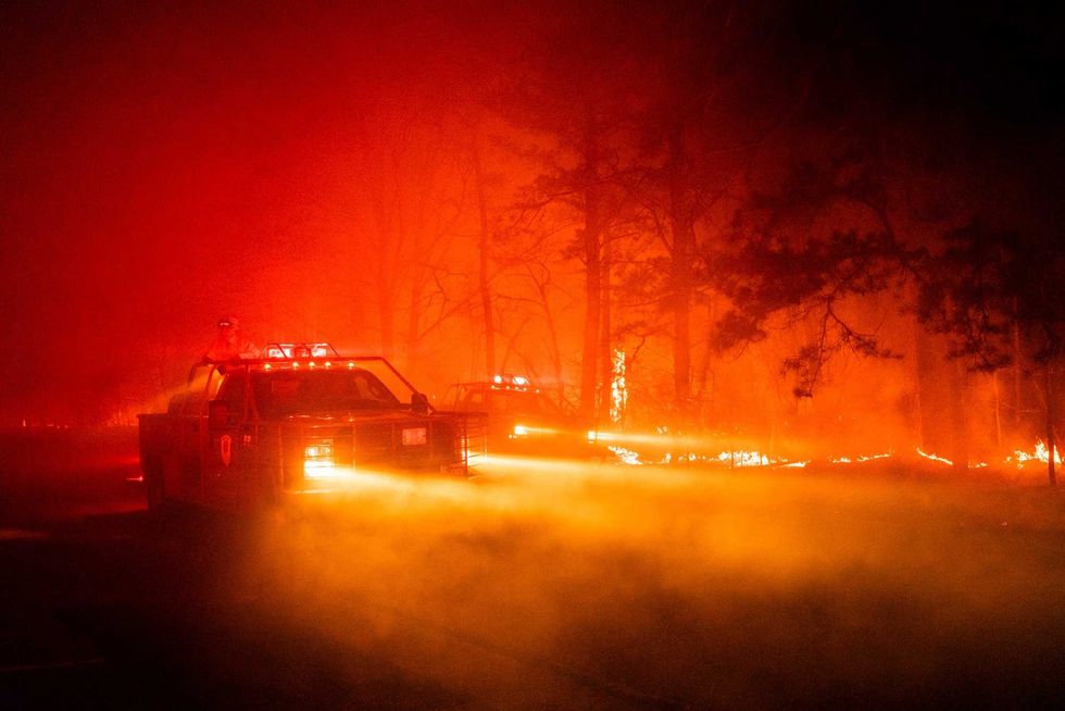 In this photo provided by the New Jersey Department of Environmental Protection, a massive 2,500-acre forest fire burns in Ocean County, N.J., early Wednesday, April 12, 2023, as firefighters battle the blaze