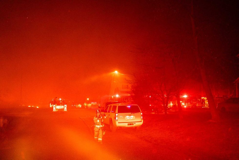 In this photo provided by the New Jersey Department of Environmental Protection, a massive 2,500-acre forest fire burns in Ocean County, N.J., early Wednesday, April 12, 2023, as firefighters battle the blaze
