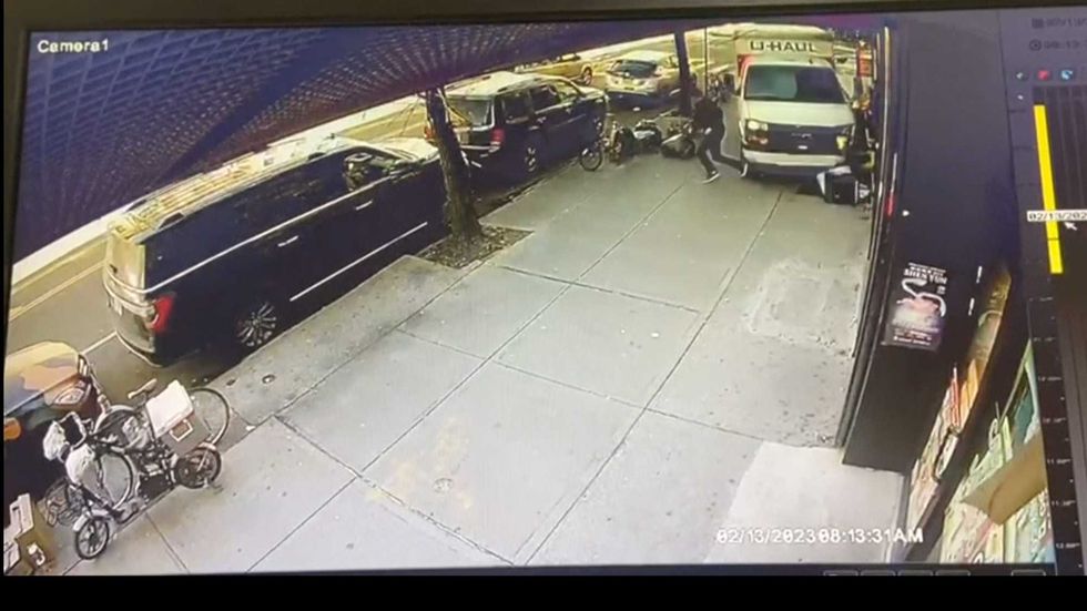 In this photo taken from security video, a man jumps out of the way as a U-Haul truck drives onto the sidewalk, Monday, Feb. 13, 2023, in Brooklyn