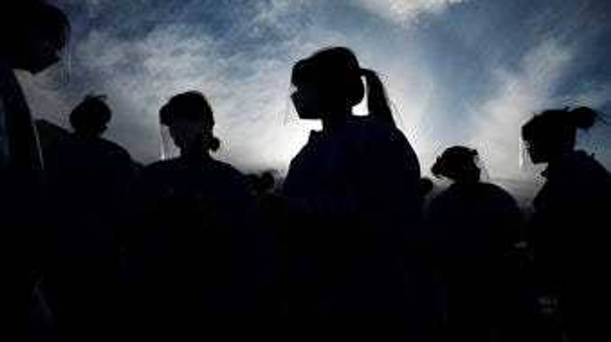 In this Saturday, March 28, 2020 file photo, medical and physician assistant students wear personal protective equipment as they prepare to screen for possible coronavirus cases at a makeshift camp for the homeless in Las Vegas.(AP Photo/John Locher)