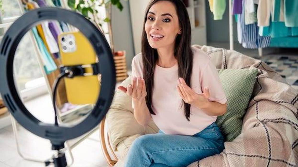 Influencer filming on her phone in front of a ring light